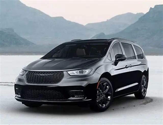 A black car is parked on the beach